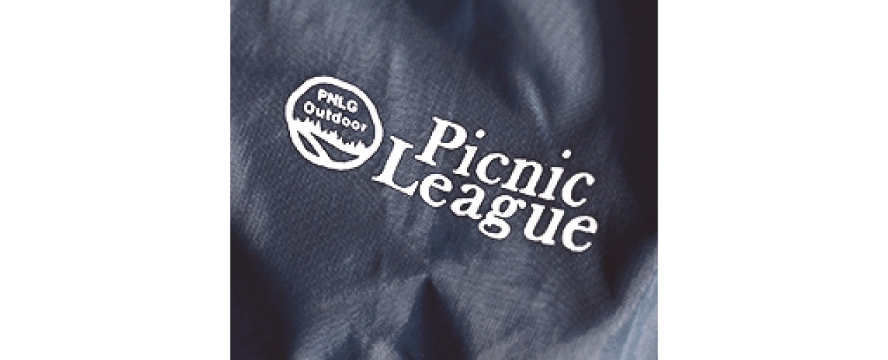 左の袖口には「Picnic League」のロゴとマークがあしらわれ、さりげないポイントに。