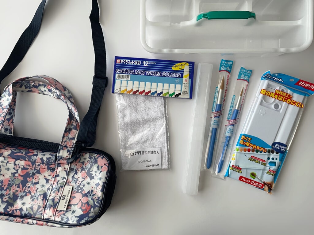 小学3年生の女の子のために準備した、ローラ アシュレイの花柄バッグと絵の具セットの中身。絵の具、筆、筆洗、パレット、雑巾などが並んでいる。