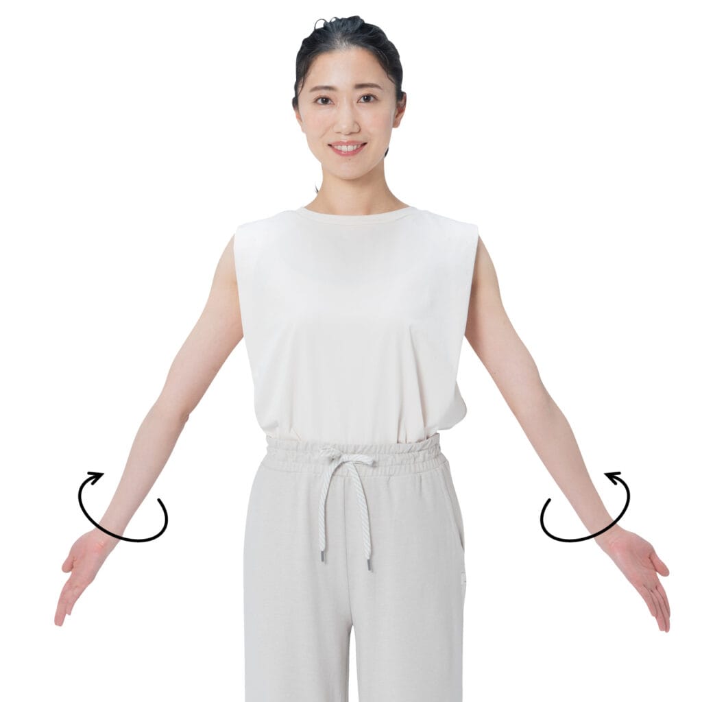 まっすぐに立ち、両手を軽く広げて両腕を外側にねじる