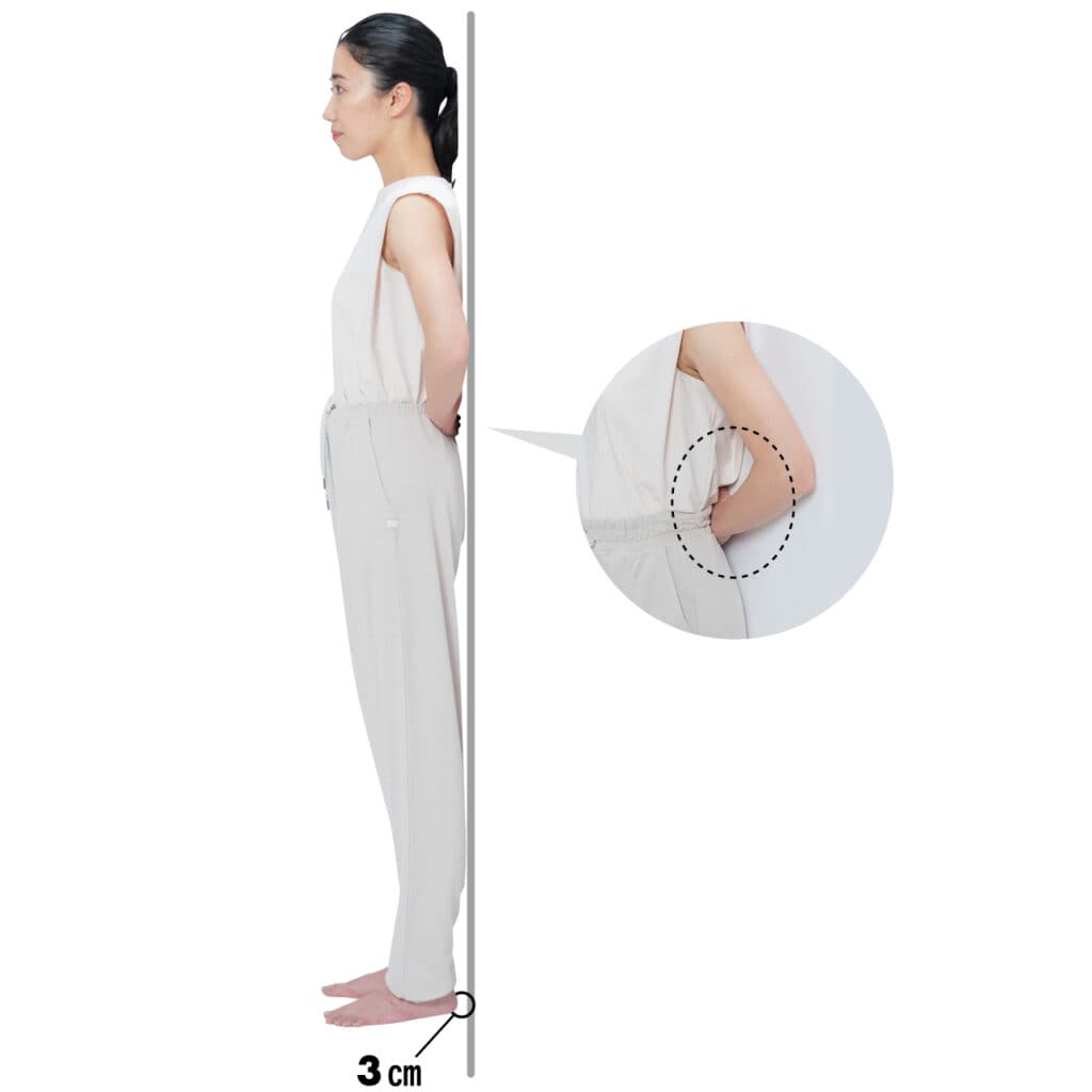 壁に肩甲骨とお尻をつけて立ち、壁と腰の間に手が入るかチェック