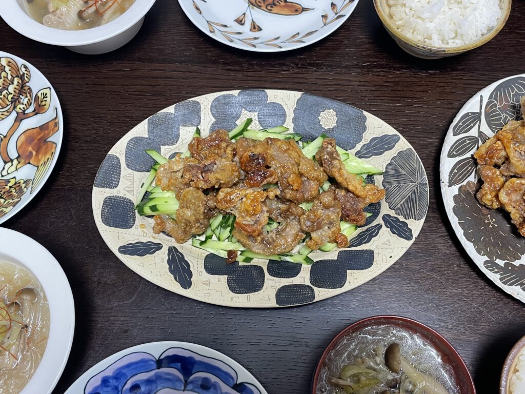 長谷川あかりさんのレシピ「豚こま肉のカリカリ甘味噌絡め」を40代の主婦が作ってみた時の写真。佐藤尚理さん作陶のオーバル皿に盛り付けられている。豚こま肉のカリカリ甘味噌絡めの下には刻んだきゅうりが敷かれている。