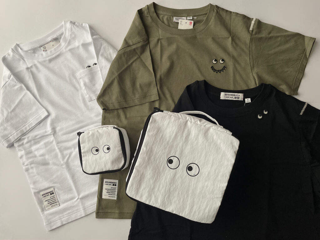 LEE100人隊TBはなが発売日に購入した、ユニクロ×アニヤ・ハインドマーチコラボの5点。Tシャツが色違いで3枚、WHITEとGREENとBLACK、それぞれデザインが違っている。白のスクエアポーチが大小並んでおり、eyesがあしらわれている。