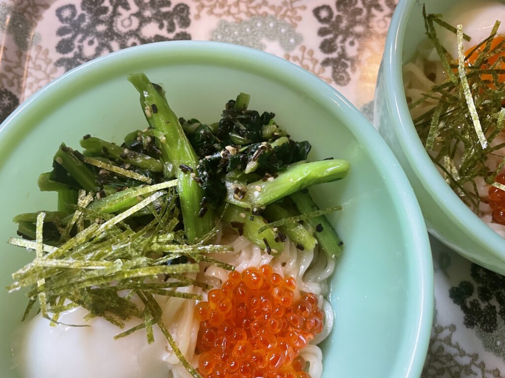 小松菜の塩昆布ごま和えを冷やしうどんに添えた写真。