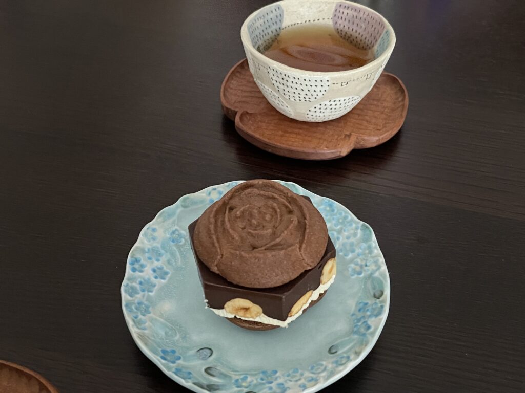 「フレッシュ・チューリップローズ＜プラリネチョコレート＞」を、うつわやみたす作陶の器にのせた写真。