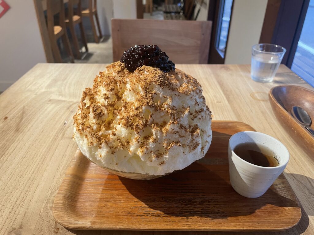 カフェクノップゥのかき氷、黒米きなこ。手前には熱いお茶が入っている。