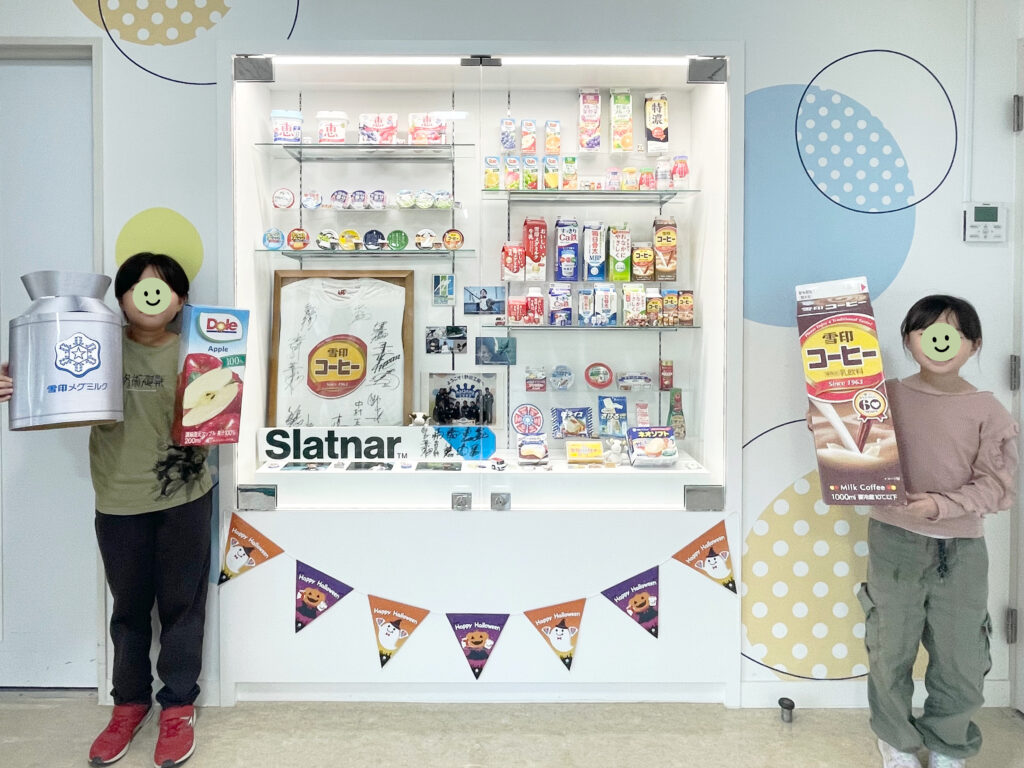雪印メグミルク野田工場のフォトスポット1。フォトプロップスを持って撮影する小学生男女。