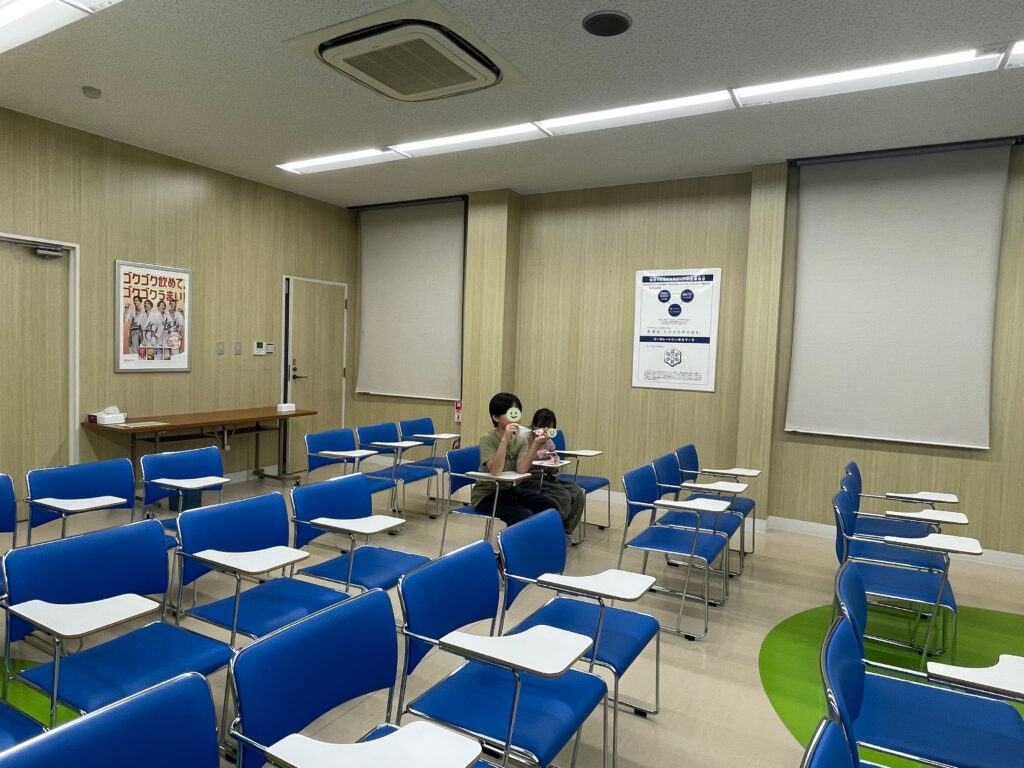 雪印メグミルク野田工場のPRルームにて、牛乳とヨーグルトを試食中の小学生男女。