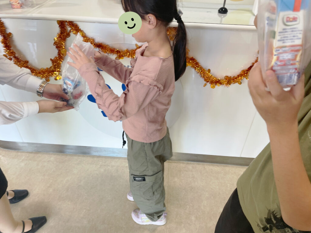 雪印メグミルク野田工場の見学ツアーに参加後、お土産をもらう様子。