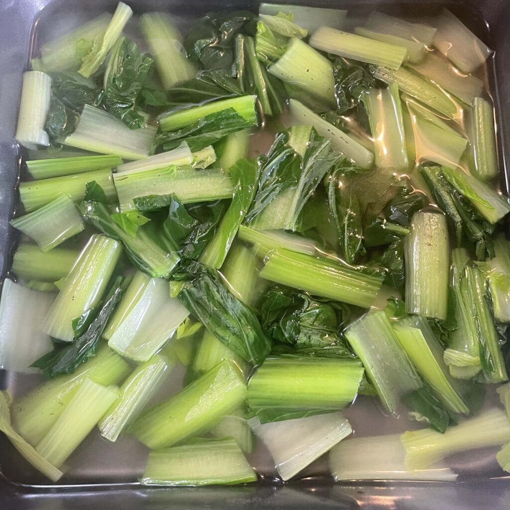 長谷川あかりさんのレシピ「小松菜の塩おひたし」を作る途中、バットの中で浸している写真。