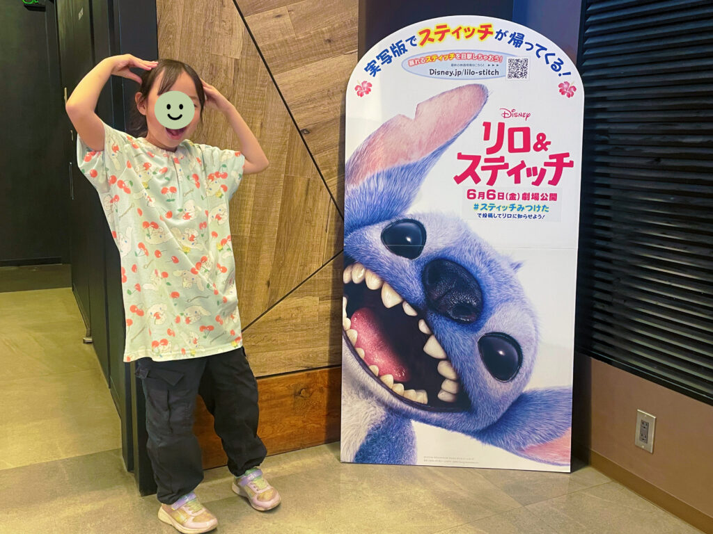 実写映画『リロ＆スティッチ』のパネルの前でポージングする小学生女児。
