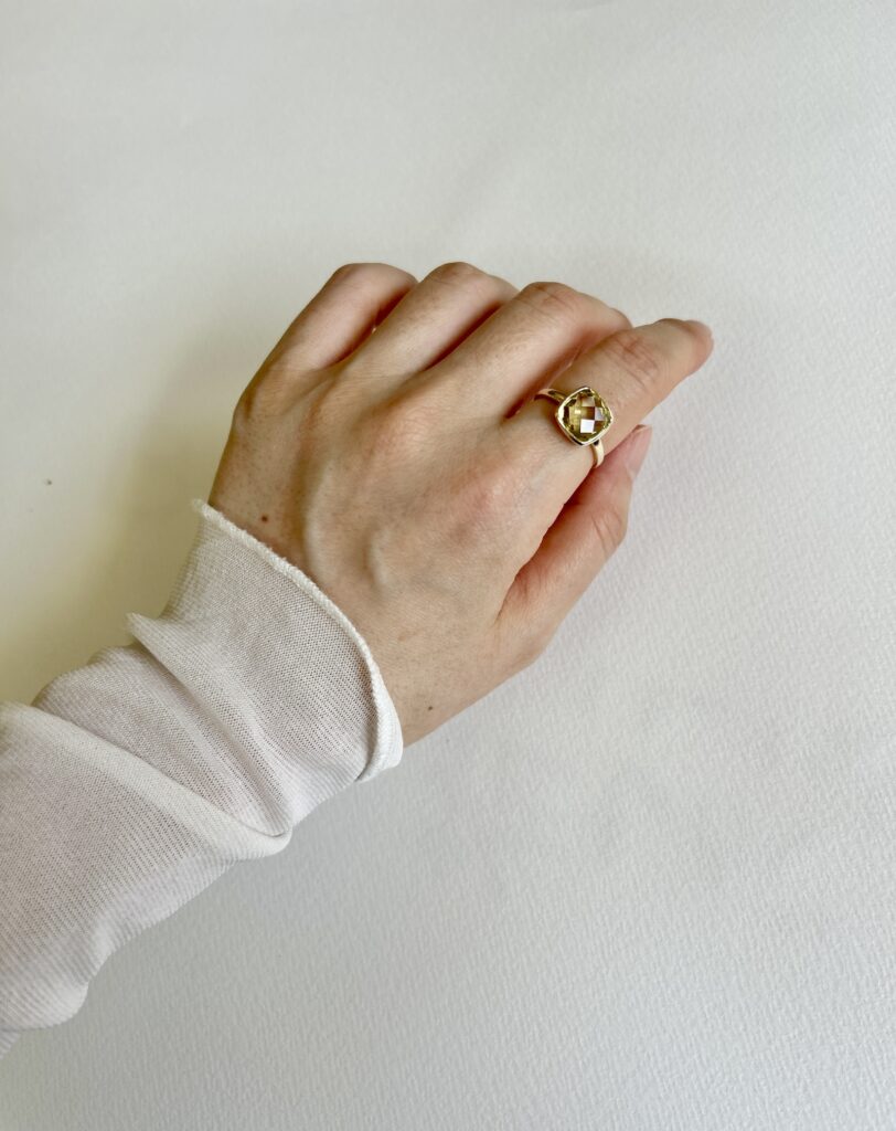 ジュエリーツツミのレモンクォーツ リングをシアートップスに合わせた手元の写真