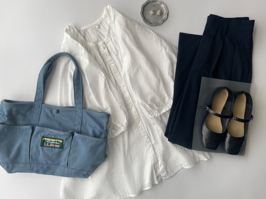 40代女性の2025年6月下旬コーデ。GUの白ブラウスと、メルローのワイドパンツ（ネイビー）を合わせている。LEE×L.L.Beanコラボのダスティブルーのカタディン・キャンピング・トートやGUのワンストラップシューズを並べたフラットレイ画像。