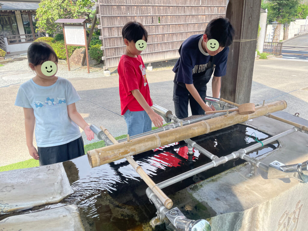 手水舎で手や口をすすぎ浄める子ども達
