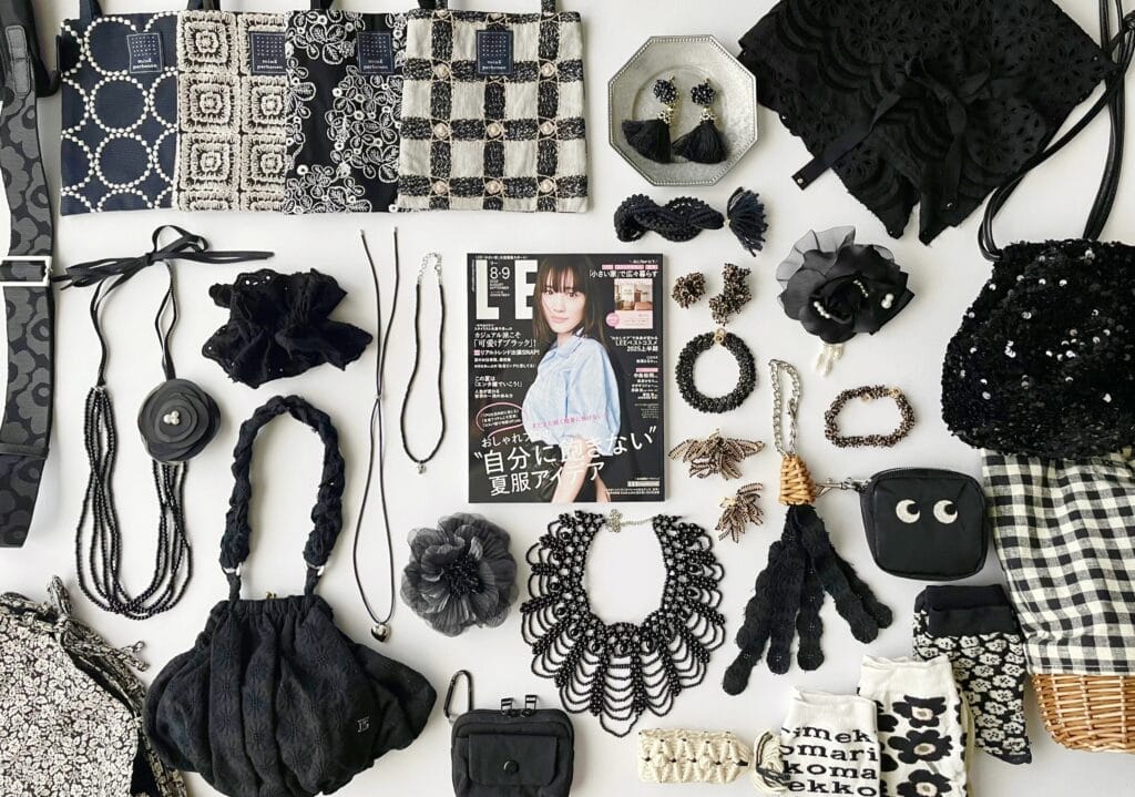 LEE8・9月合併号（2025年）の周りに、「可愛げブラック」特集にリンクして黒のファッション小物、ソックスやアクセサリー、バッグ、ショールなどが並べられている。