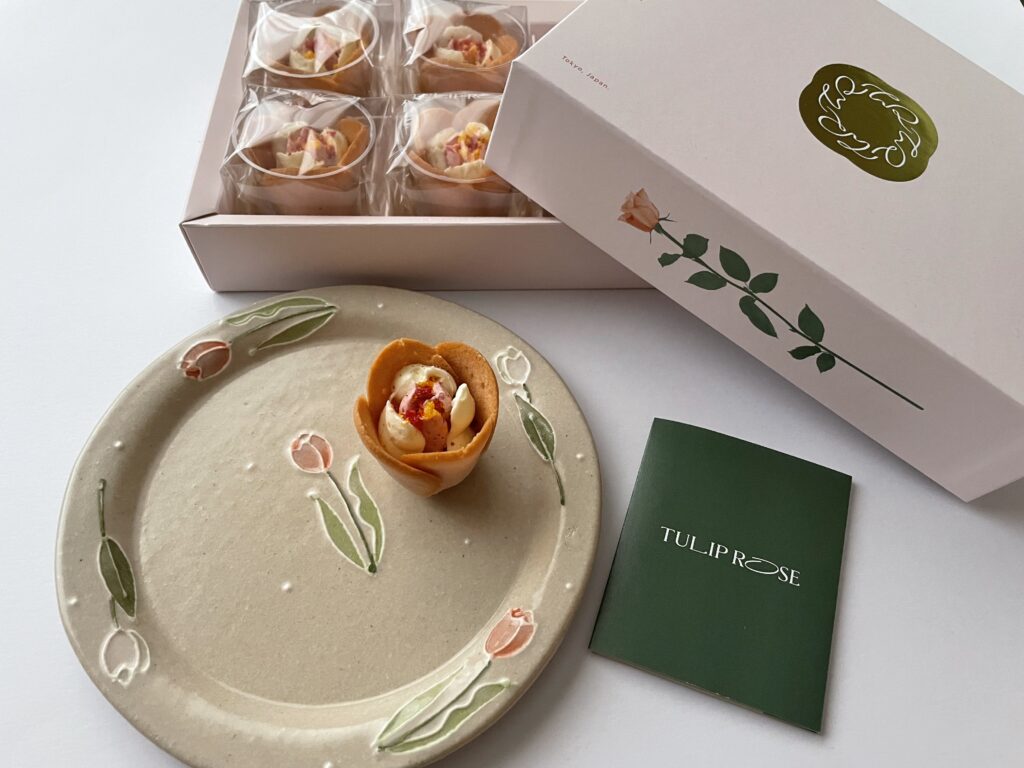 チューリップローズ＜白桃フロマージュ＞を、チューリップ柄のお皿にのせている写真。