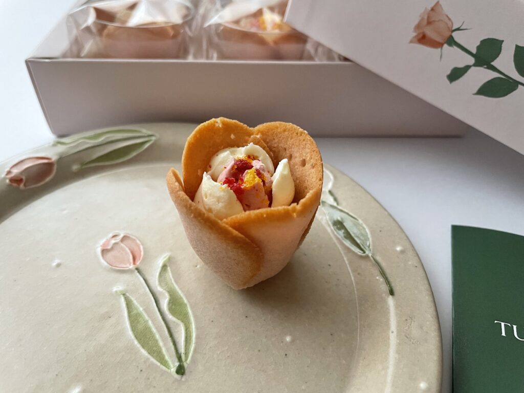 チューリップローズ＜白桃フロマージュ＞を、チューリップ柄のお皿にのせている写真【その2】