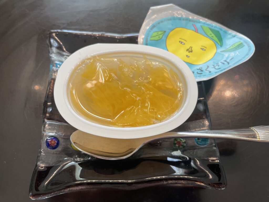 「因島のはっさくゼリー」が四角い形のガラス製のお皿にのせられている。蓋を開けた後の写真。