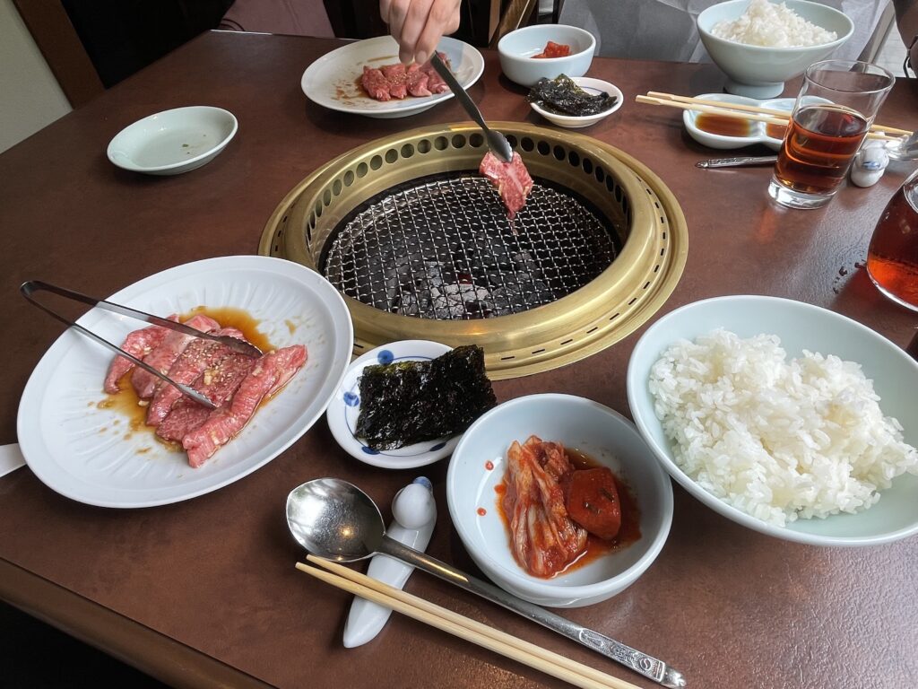 壱語屋での焼き肉ランチ。牛カルビを炭火の網の上で焼く様子。