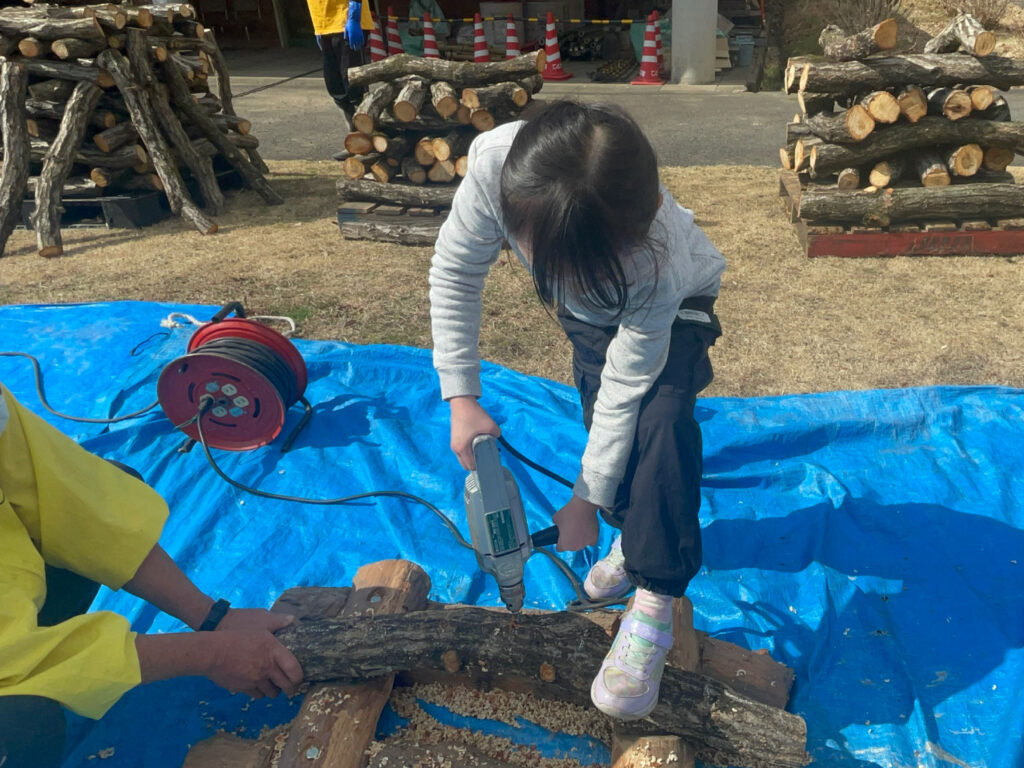 ほだ木にドリルで穴をあけるところ