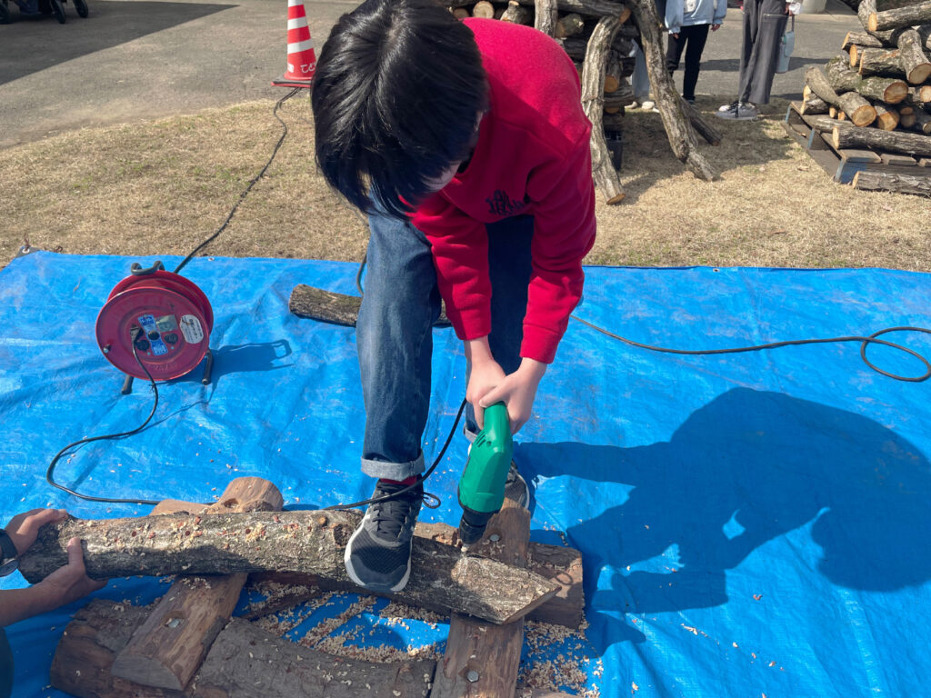 原木にドリルで穴をあけるところ