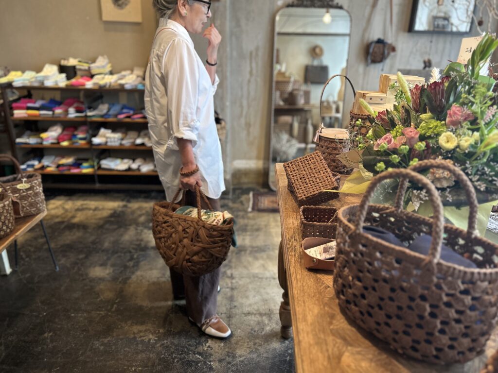 60代の山葡萄のかごバッグを持ったグレイヘアの女性