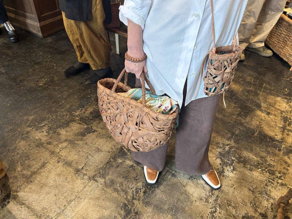 60代の山葡萄のかごバッグを持ったオシャレな女性