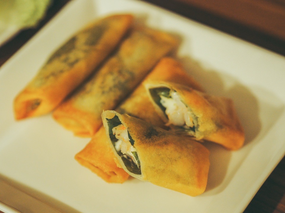 白いお皿のうえのカットされたエビ春巻き