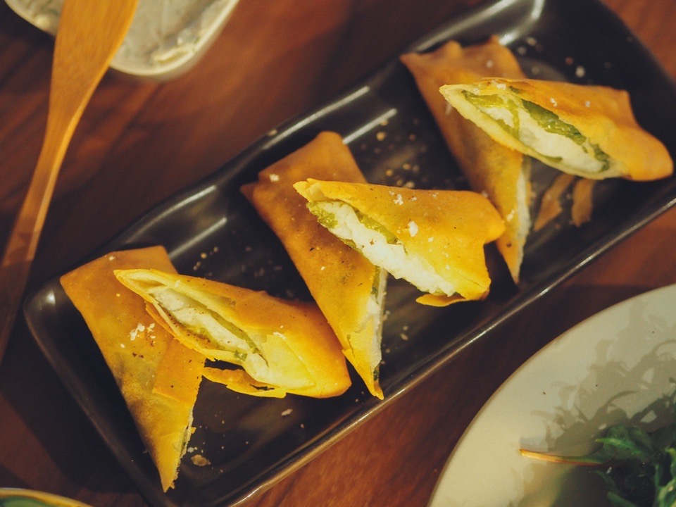 黒いお皿の上のカットされた長芋の春巻き