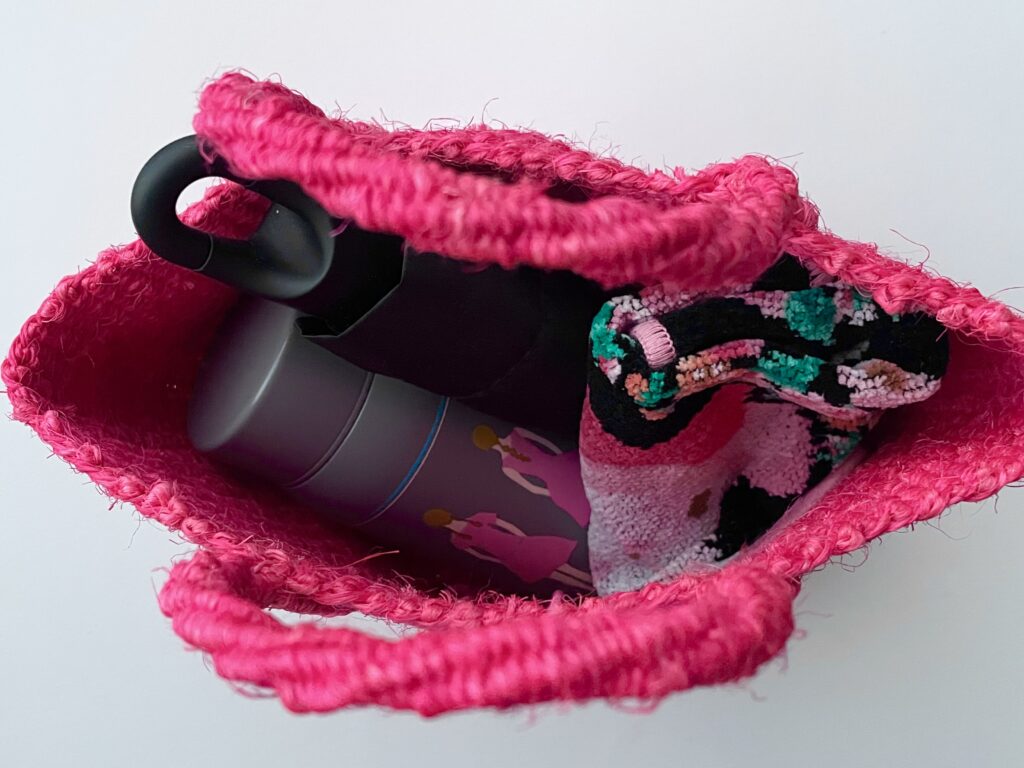 acuttiで購入したローズピンクのザイザルバッグに水筒などを入れた写真