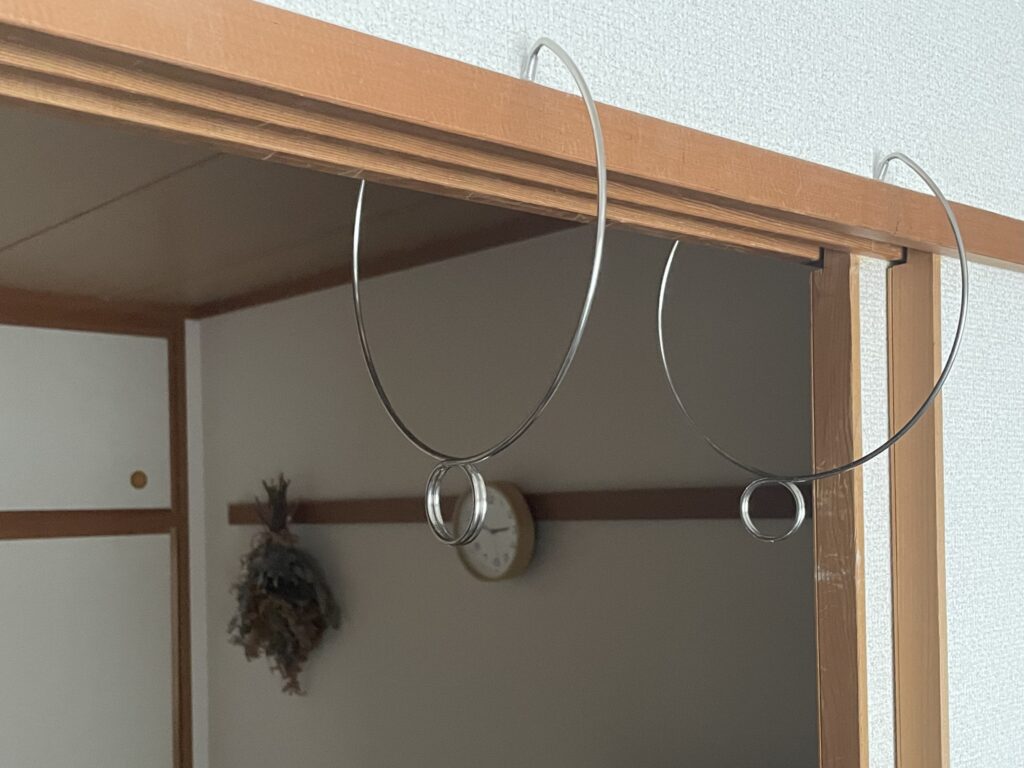 我が家の鴨居に、セリアの「ステンレスかもいハンガー」を挟み込んだ写真。