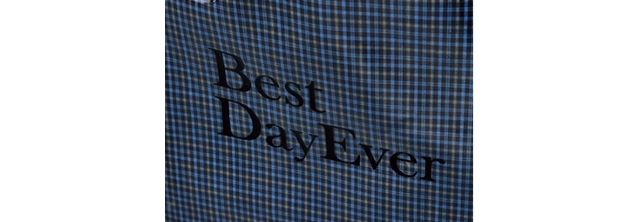 柄は紺系チェックと白×紺ストライプ。片面にブランドロゴ、反対面に「Best Day Ever」のロゴ入り。