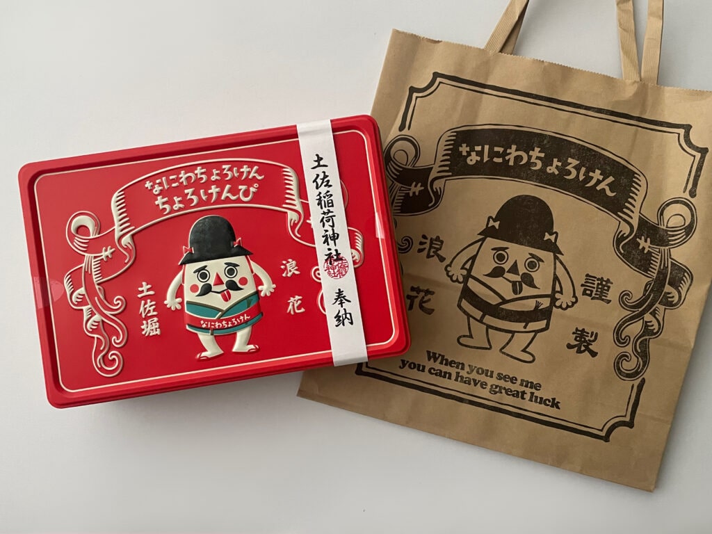 (株)一創堂の「なにわちょろけん」の紙袋と、芋けんぴ「なにわちょろけん ちょろけんぴ」の缶が並んだ写真。