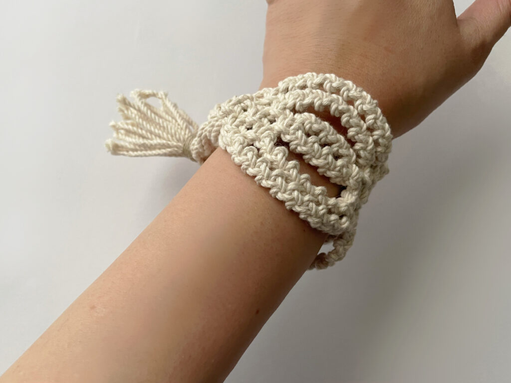 Tamiさんのマクラメ編みのアクセサリー、abara（白）のバングルを手首につけてみた写真。