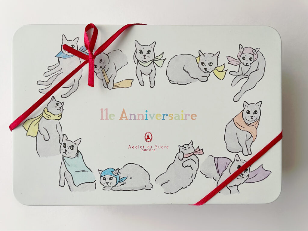 アディクト・オ・シュクル（Addict au Sucre）11周年記念缶「オーンズ シャ」の缶。赤のリボンがかかっている。