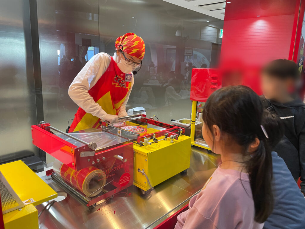 マイU.F.Oファクトリーでの一コマ。蓋をカップに圧着している様子。