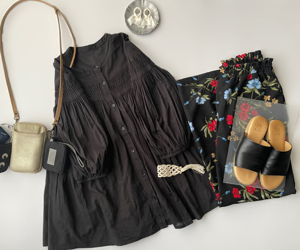 40代女性の2025年8月下旬コーデ【その3】。ボンジュールサガンの黒ブラウスとShelly Islandの花柄パンツを合わせたフラットレイ画像。