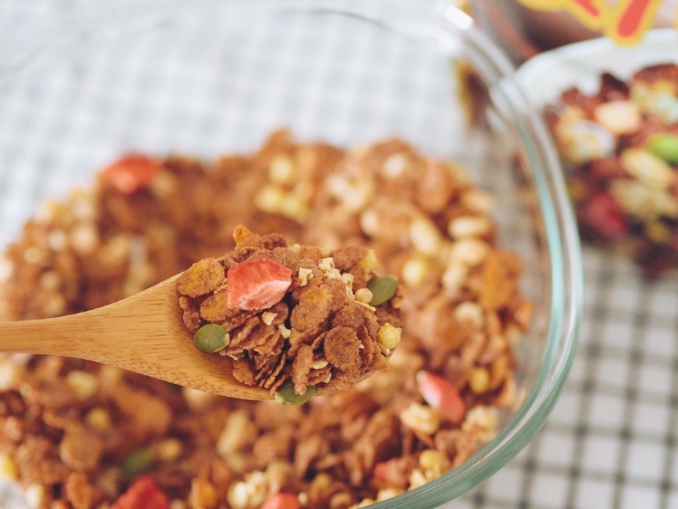 素材まるごとグラノラ 脂質70%オフを木のスプーンですくったグラノラのアップ