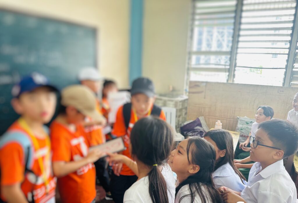 「ジュニアビジネス留学サマーキャンプ2025」で現地校の小学生に質問する参加者