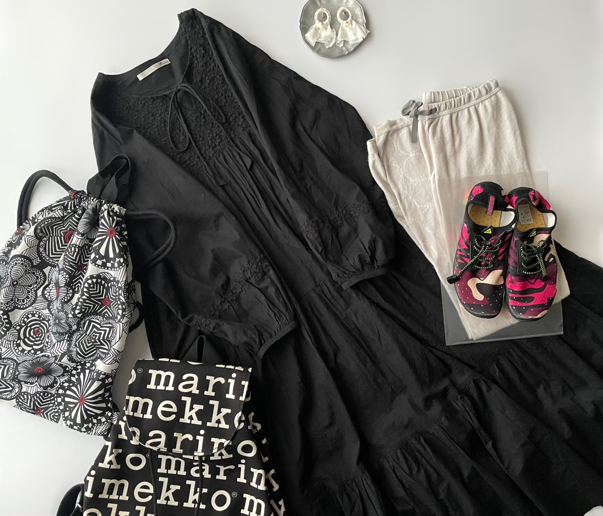 40代女性の2025年8月下旬コーデ、Fanakano 黒の刺繍ワンピースとミナペルホネンのtambourine柄レギンスを合わせたフラットレイ画像。