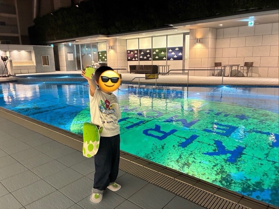 アパホテルリゾートのプールの前でポーズをとる男の子