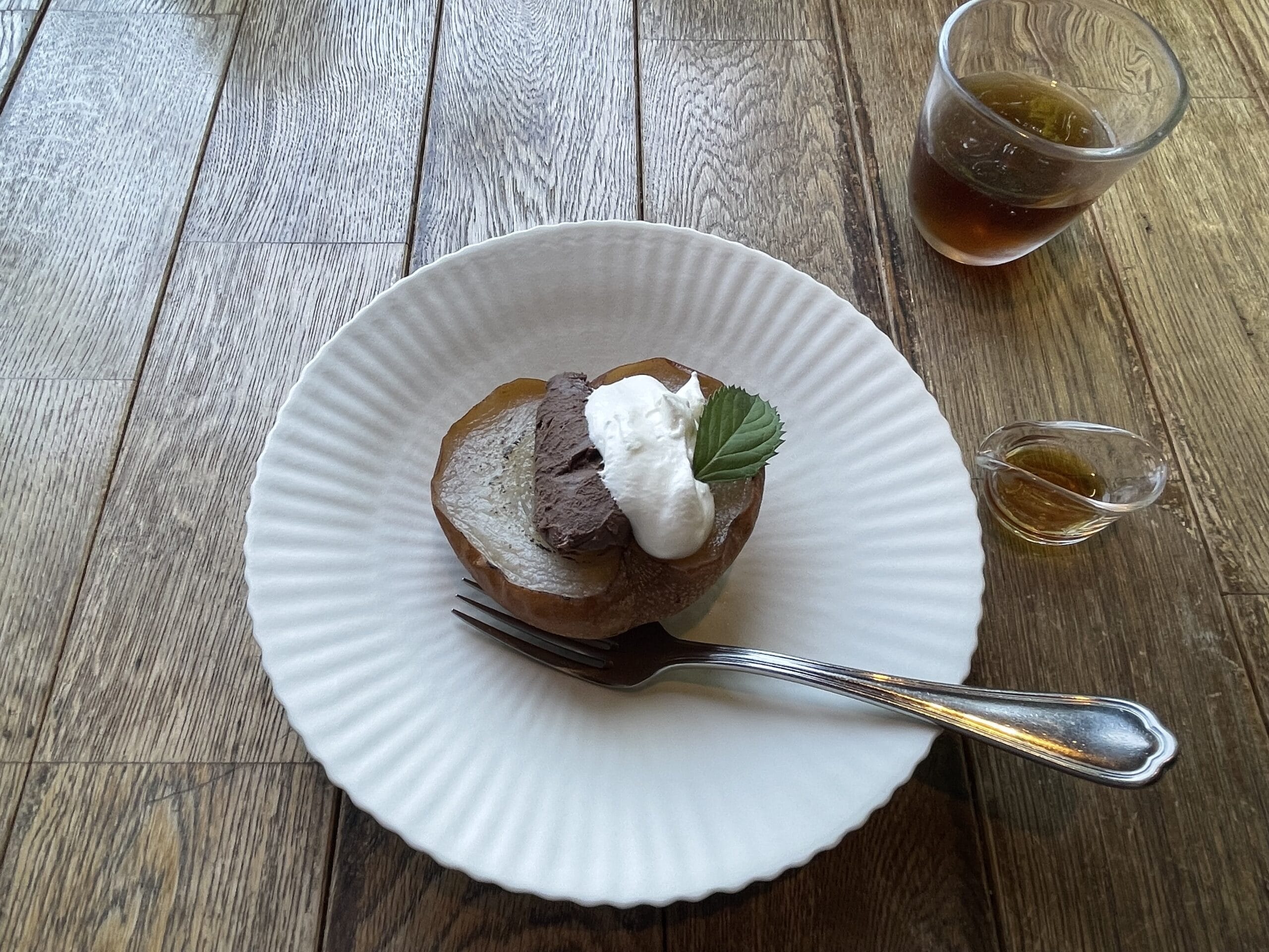 焼き梨とチョコガナッシュのスパイスラム添えが白い器に盛り付けられている。JIKE STUDIOのカフェにて。