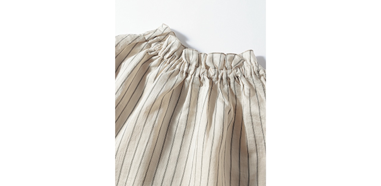 優しく顔映えするフリルのスタンドカラー。