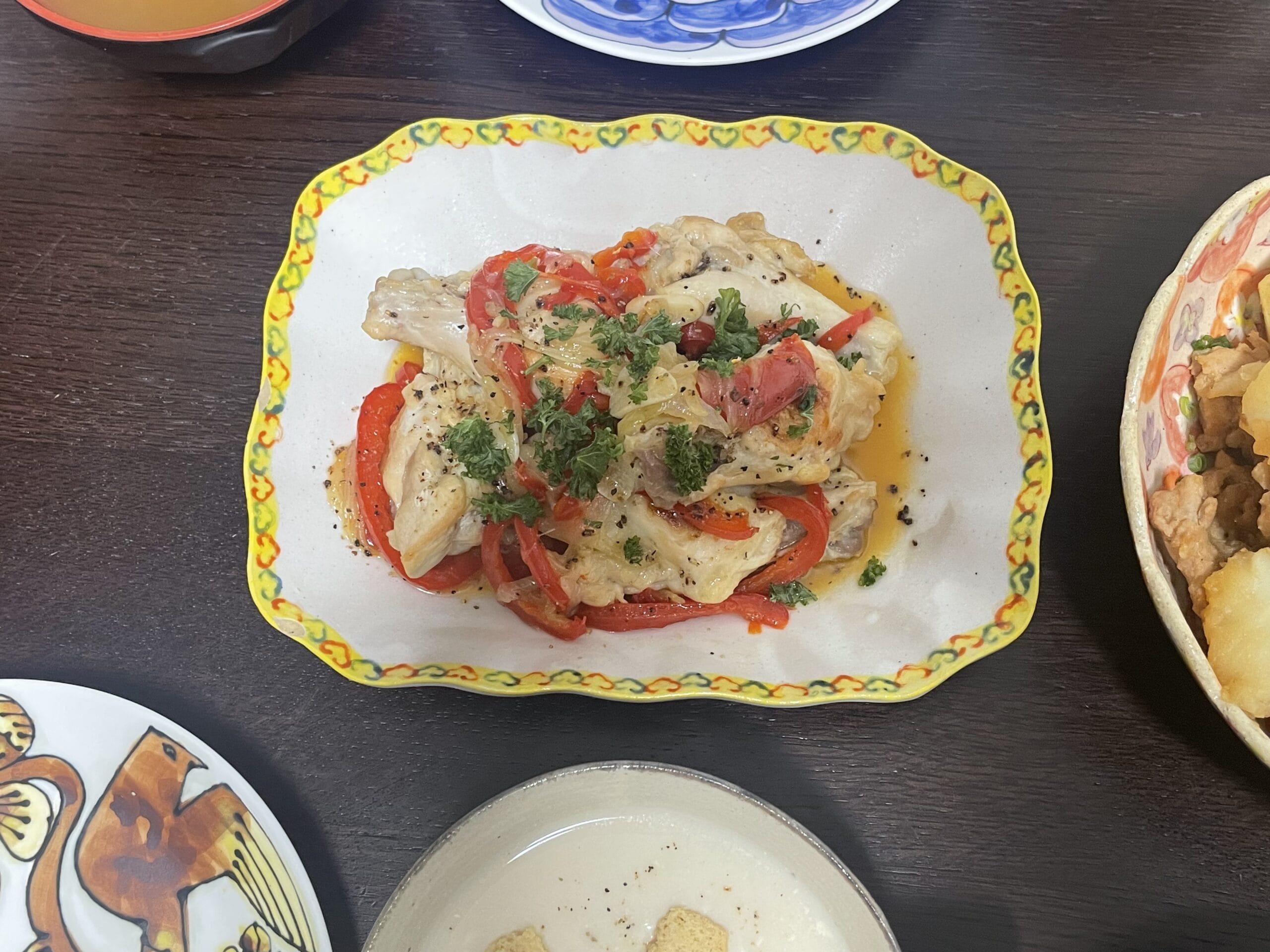 コウケンテツさんのレシピ「手羽元とパプリカの柔らか蒸し煮」を40代主婦が作り、ヨシノヒトシさん作陶のお皿に盛り付けた写真。