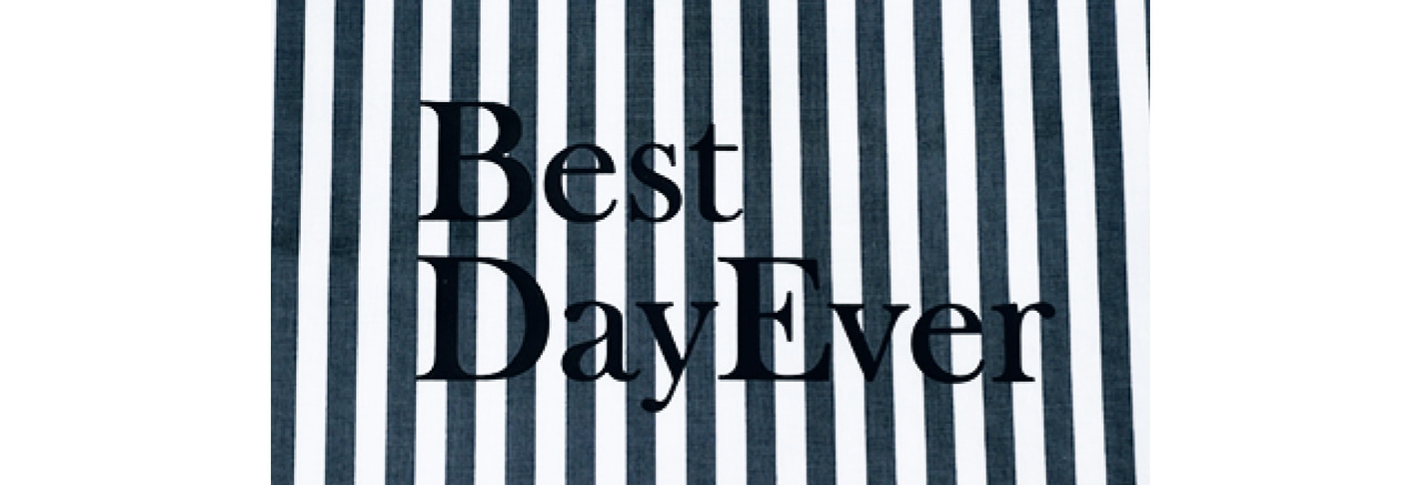 柄は紺系のチェックと白×紺のストライプ。片面にブランドロゴ、反対面に「Best Day Ever」のロゴ入り。