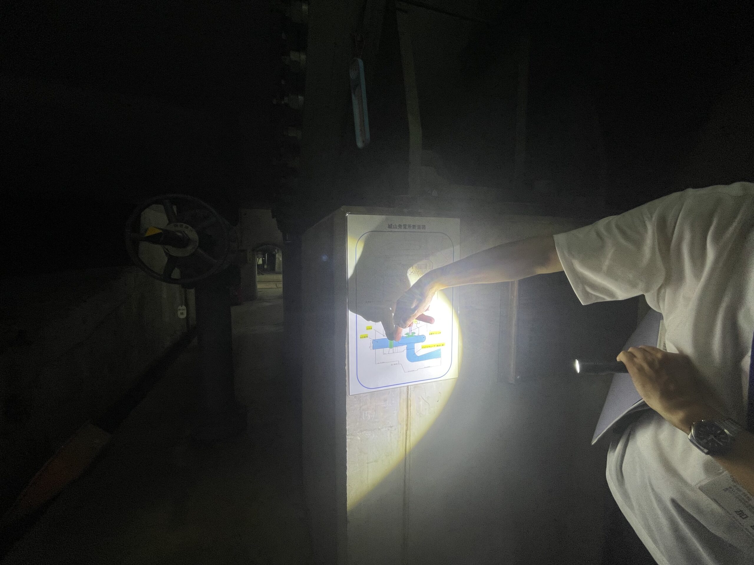 城山発電所の断面図を使って説明をしてもらっている場面