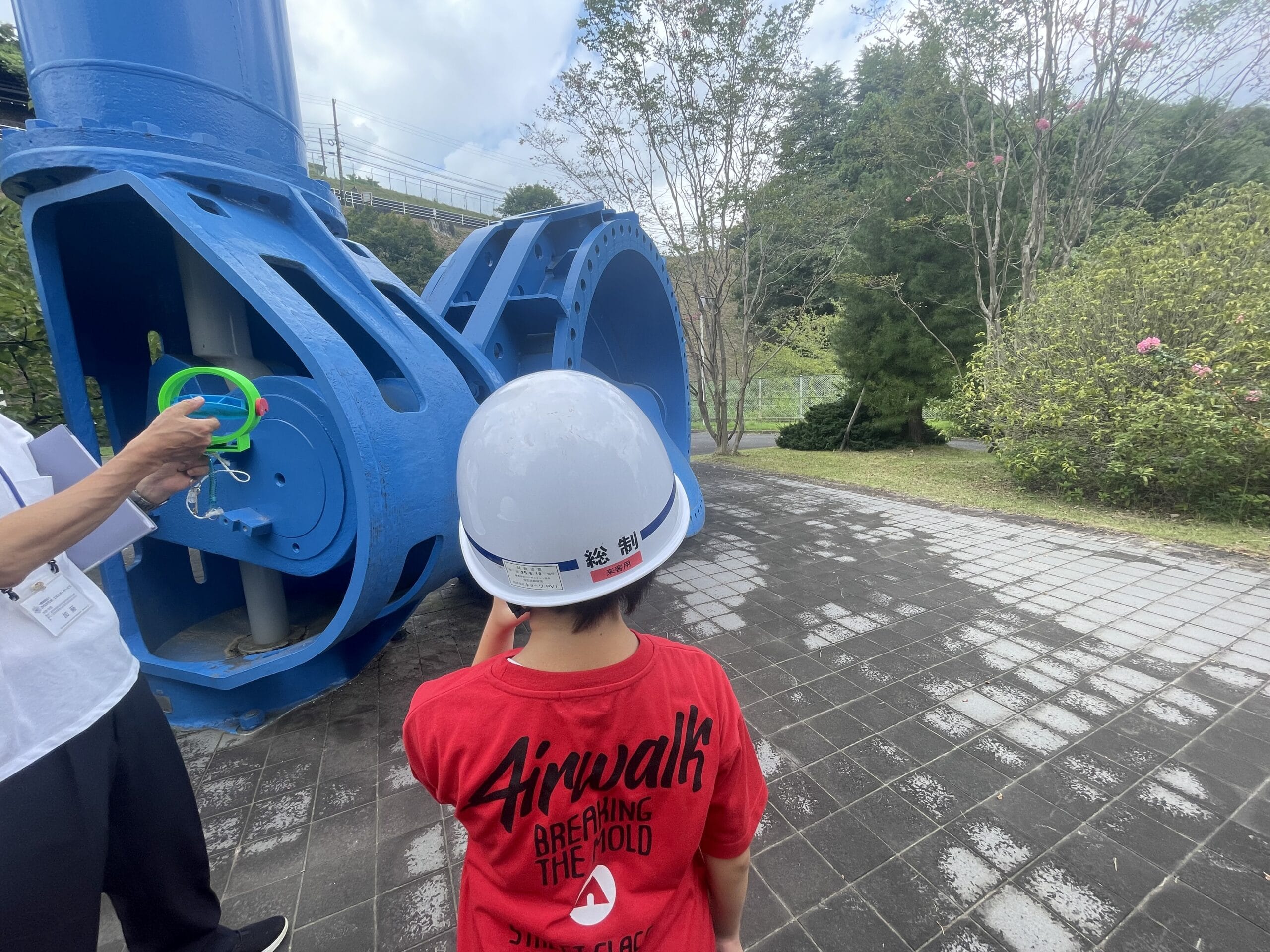 入口弁のモニュメントを使って解説を聞く場面