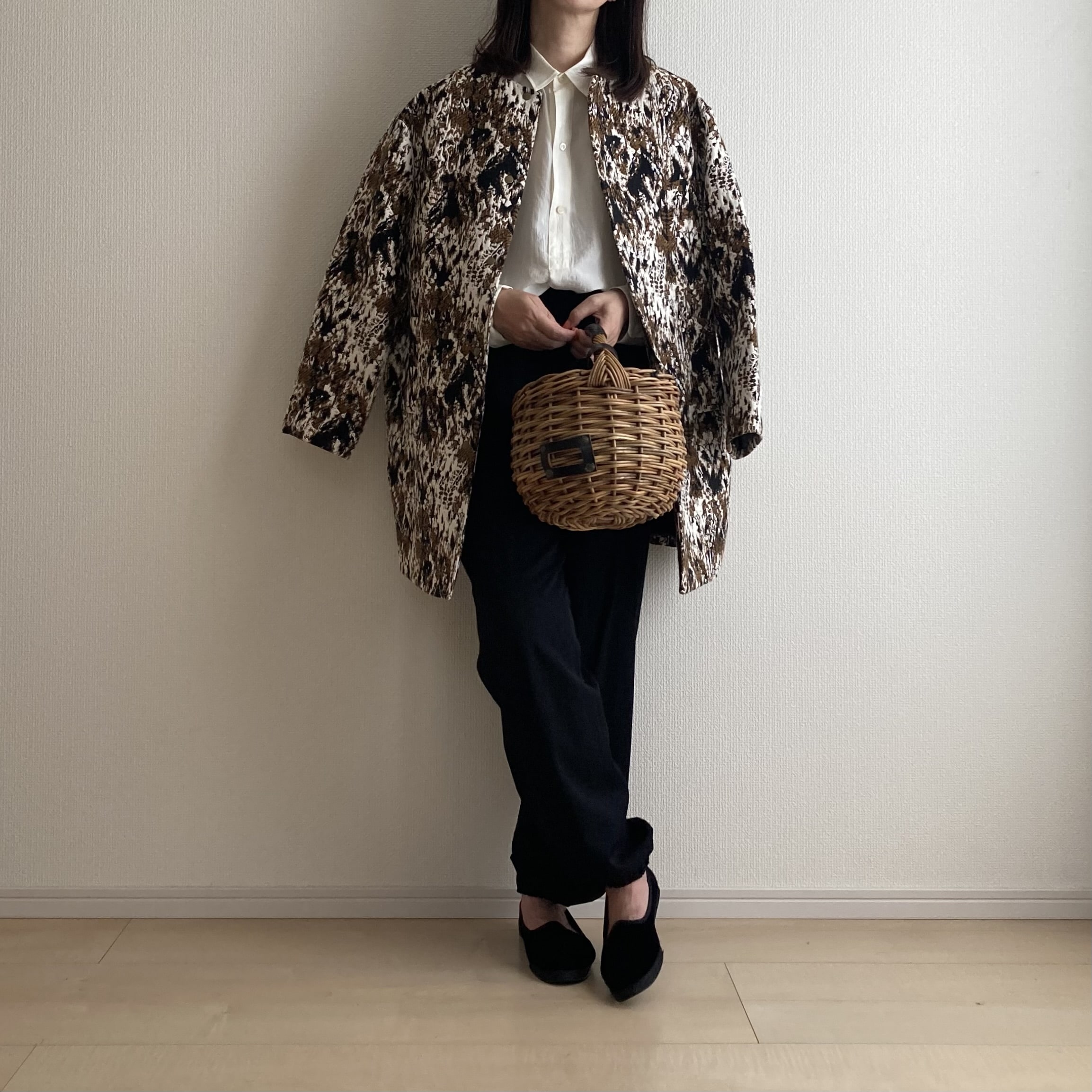 40代女性長袖シルクブラウスにコート羽織っている