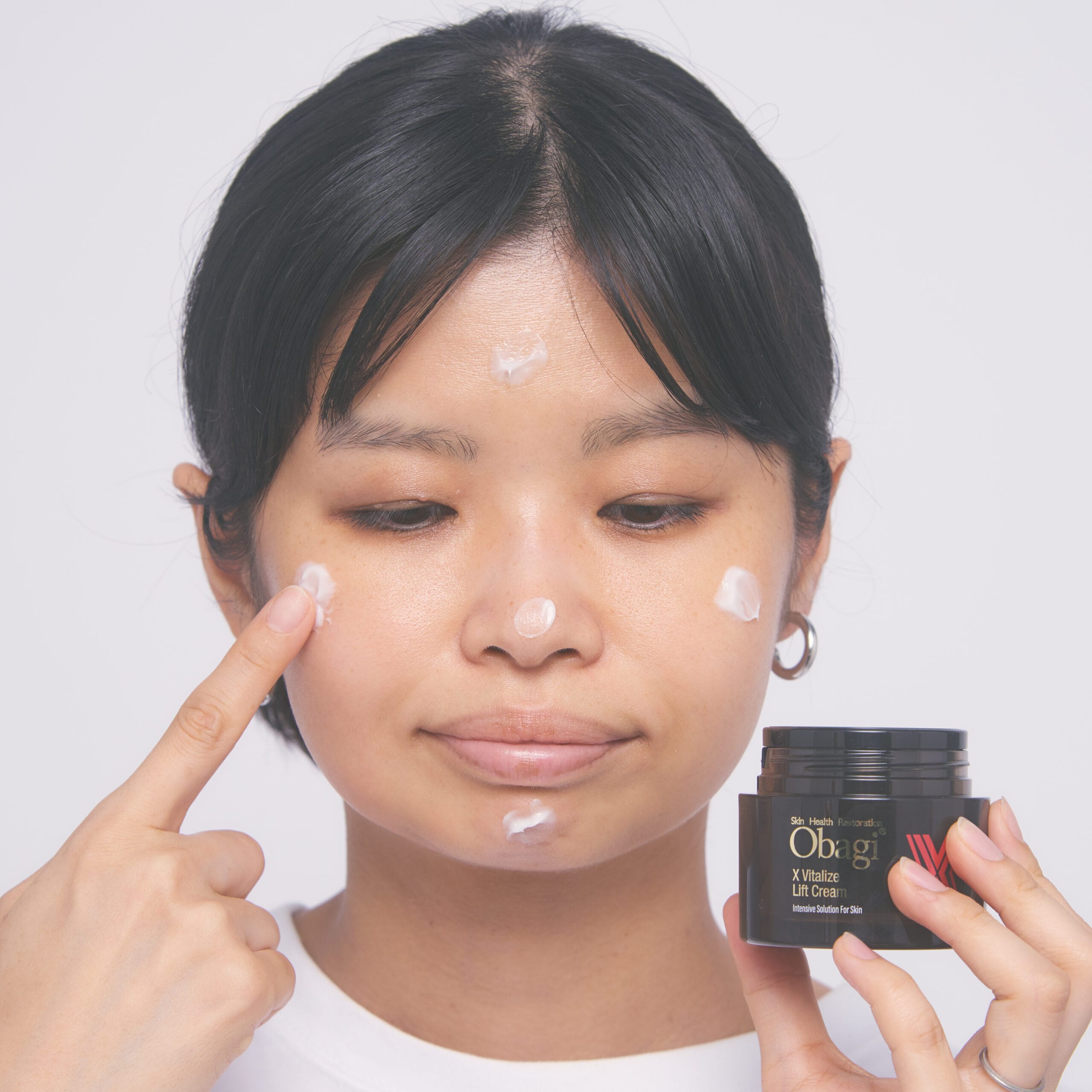 バイタライズ リフトクリームを顔に5点置きしているところ