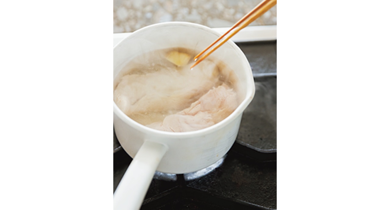 鍋に水としょうがと長ねぎを入れて沸騰させる。砂糖と塩を加え、縦半分に切った鶏むね肉を入れる。