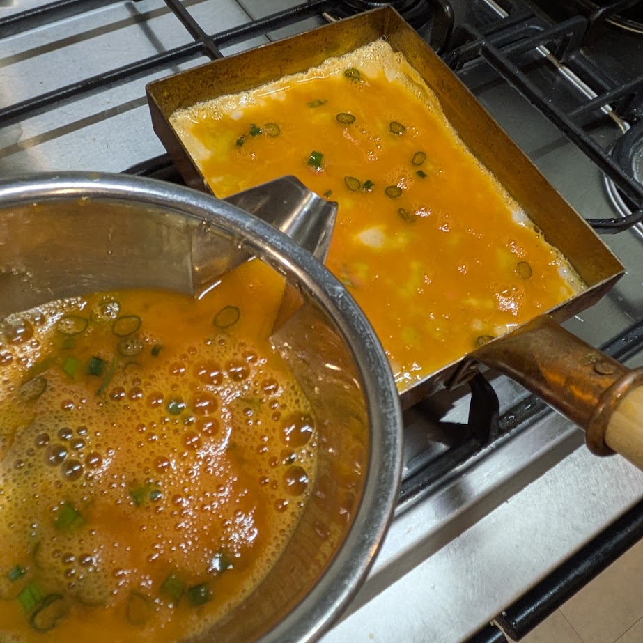 銅製の卵焼き器で卵焼きを作る様子